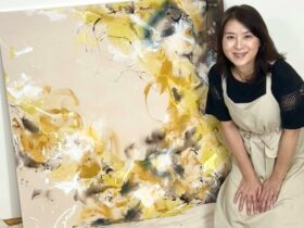 Artist Seiko Hoashi next to her abstract yellow painting